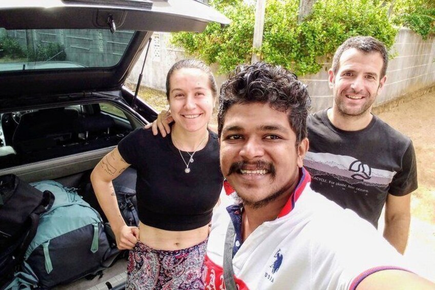 Three people standing by an open car trunk with luggage. 4