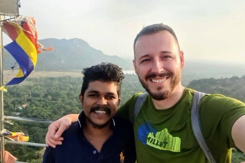 Two people standing on a high vantage point with a view of a mountainous landscape. 5