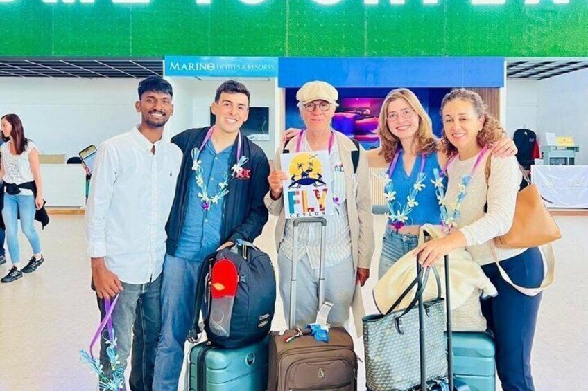 A group of people at a travel check-in area with luggage. 5