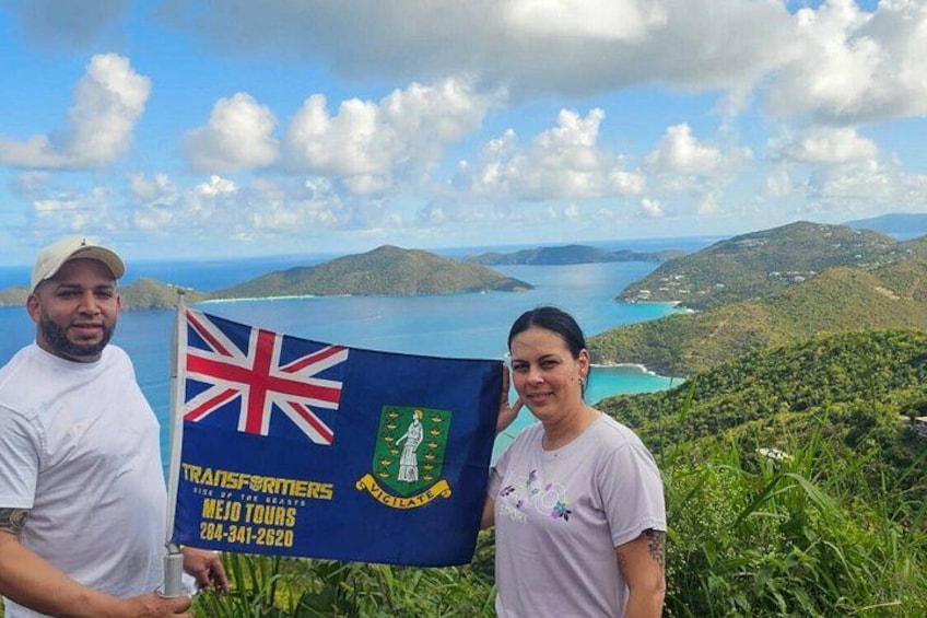 Deux personnes tenant un drapeau, avec un paysage en arrière-plan. 3