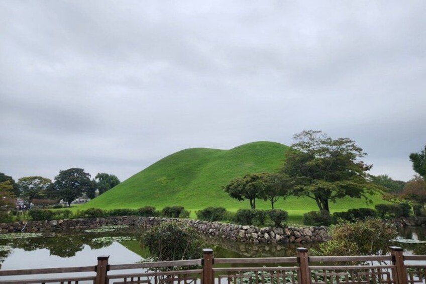 A green hill, a pond, and a wooden fence. 3
