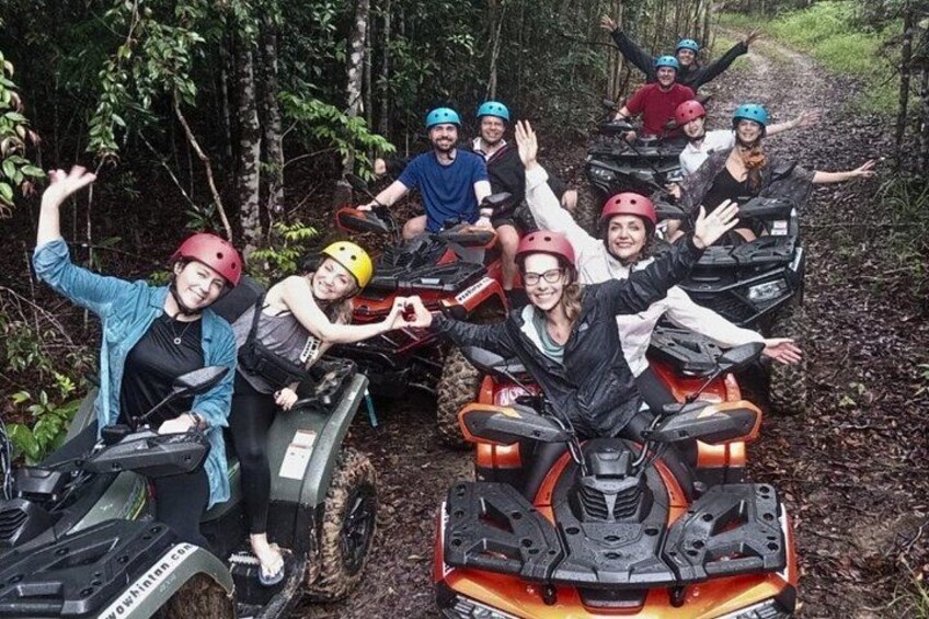A group of people on all-terrain vehicles in a forested area. 1