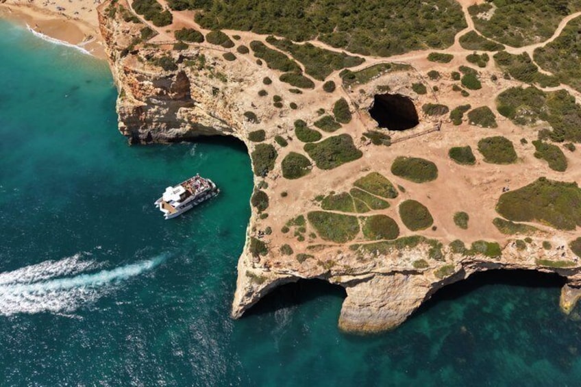 Vista aérea de una zona costera con un barco en el agua, terreno rocoso y vegetación escasa. 2