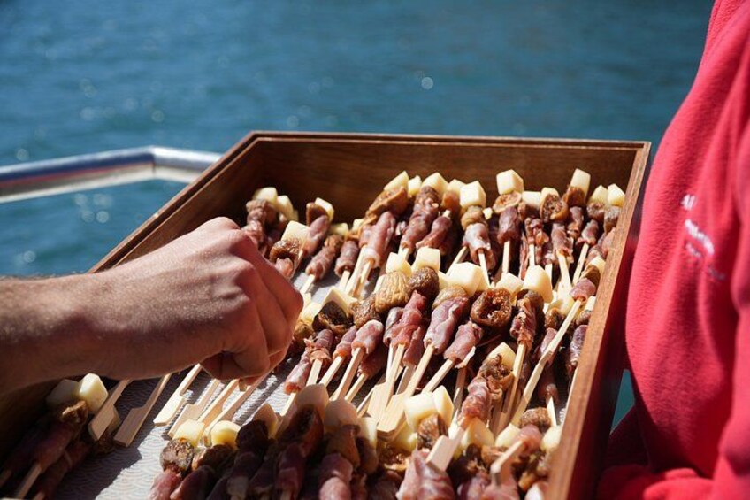 A wooden box filled with skewered food items, likely for grilling, on a boat. 2