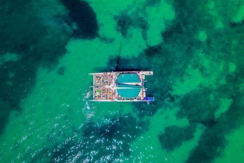 Eine Luftaufnahme einer kleinen Insel mit einem zentralen Wasserteil, umgeben von türkisblauem Wasser. 2