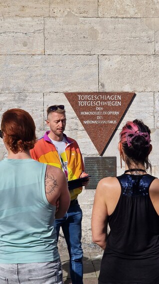 A group of people standing in front of a sign with text in German. 3