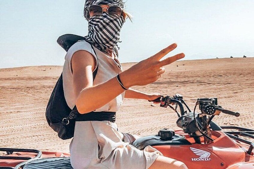 Una persona sentada en una motocicleta en un paisaje desértico. 1