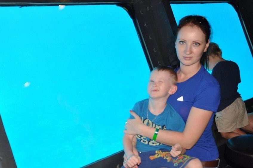 A person in a blue shirt holding a child in a blue environment. 5
