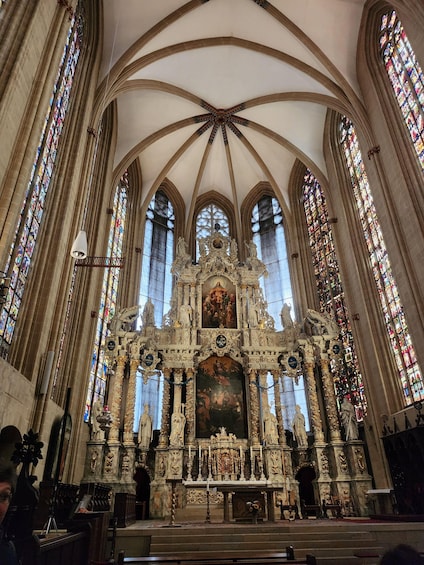A cathedral interior with a high vaulted ceiling, stained glass windows, and ornate religious statues. 3