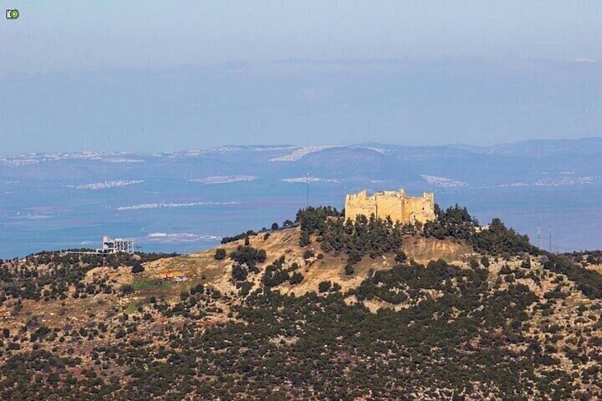 A hilltop castle overlooking a coastal landscape. 3
