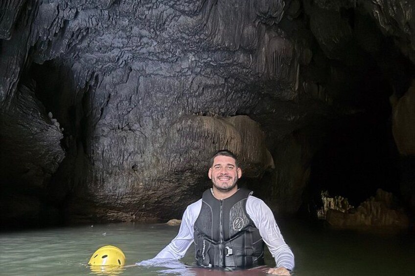 Una persona en una cueva, con un casco amarillo en el suelo. 3