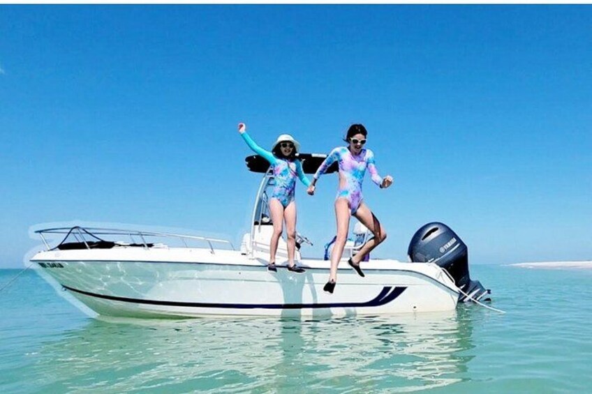 Dos personas en un bote sobre aguas cristalinas. 3