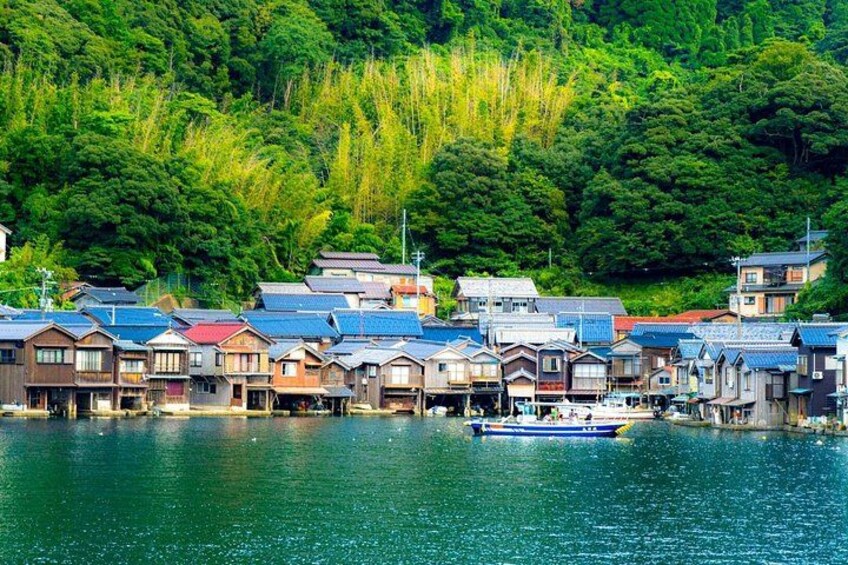 A riverside town with traditional houses and a boat on the water. 4