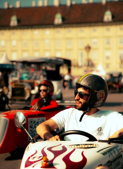 Une personne conduisant une moto sur laquelle sont peintes des flammes sur les côtés, dans un environnement urbain avec des bâtiments en arrière-plan. 3