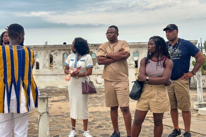 Un grupo de personas en la azotea, con un edificio histórico al fondo. 3