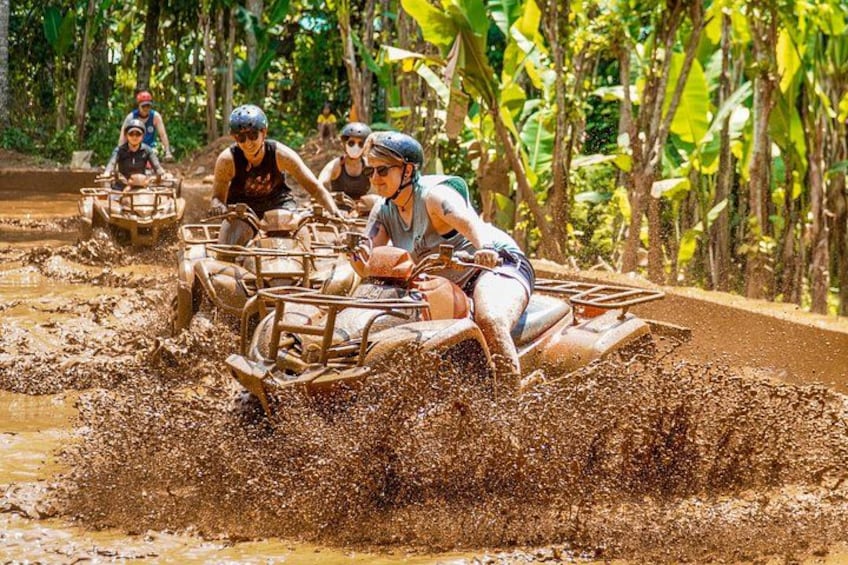 People riding atv's through a muddy area. 4