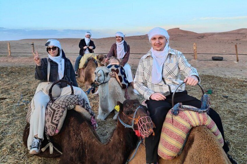Menschen reiten auf Kamelen durch eine Wüstenlandschaft. 1