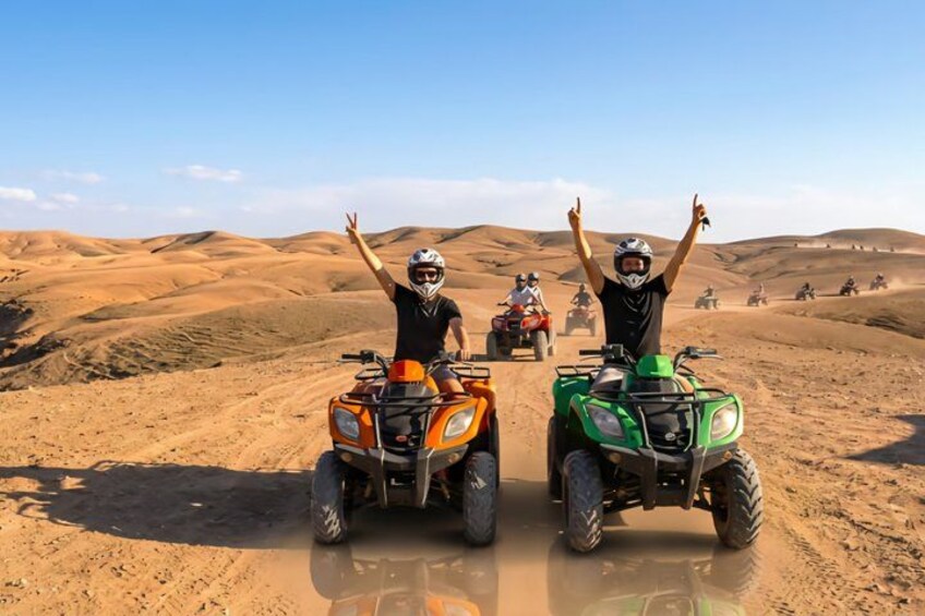 Deux personnes sur des quads dans un désert, avec des dunes de sable en arrière-plan. 2