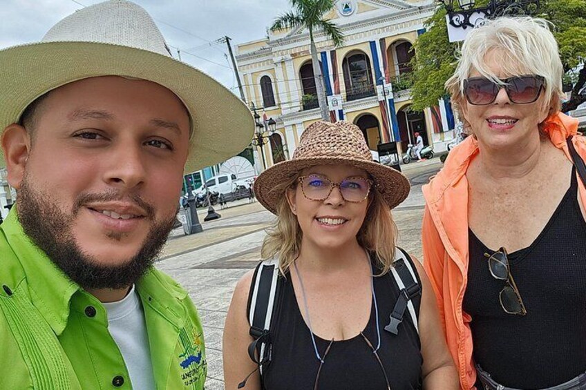 Three people in a city square with historic architecture in the background. 4