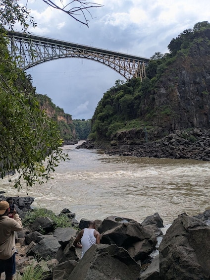 A river with a bridge, rocky terrain, and dense foliage. 4
