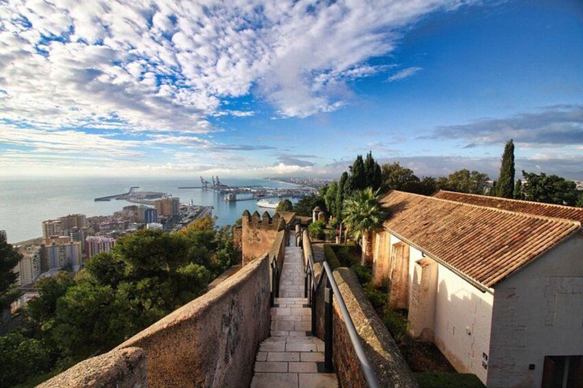 Un paisaje urbano costero con una fortaleza histórica, un puente y vistas al mar. 2