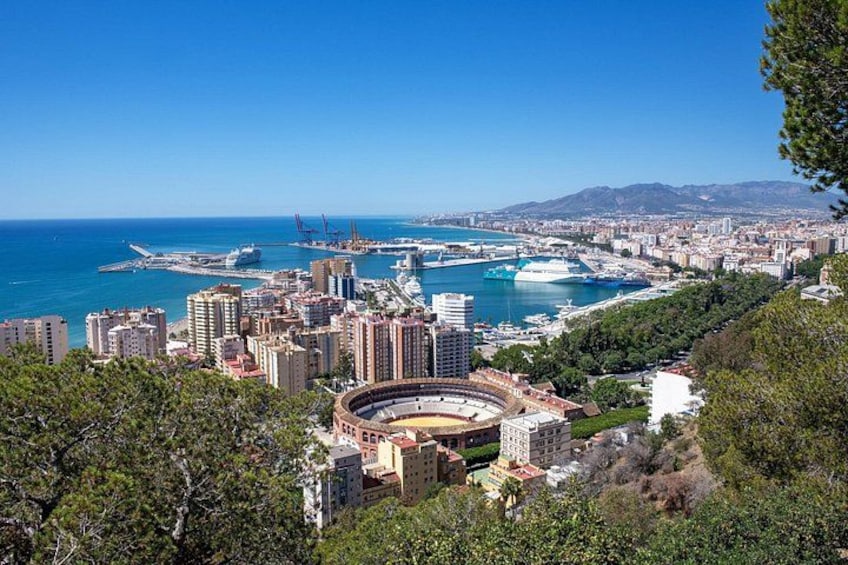 Un paisaje urbano costero con un estadio destacado, un puerto y edificios densos. 3