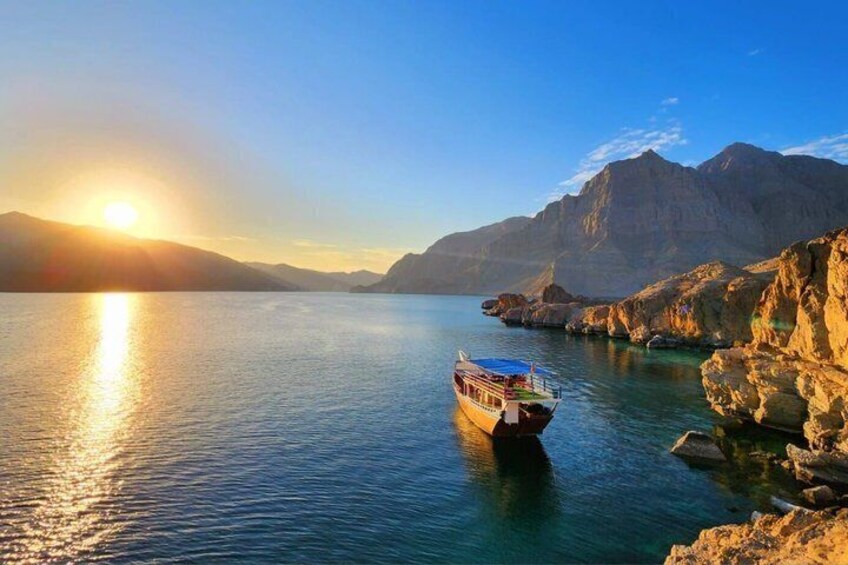 A boat on a calm body of water with mountains in the background. 5