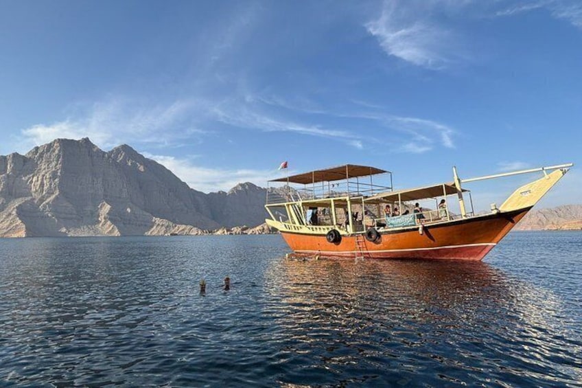 A boat on calm water with mountains in the background. 2