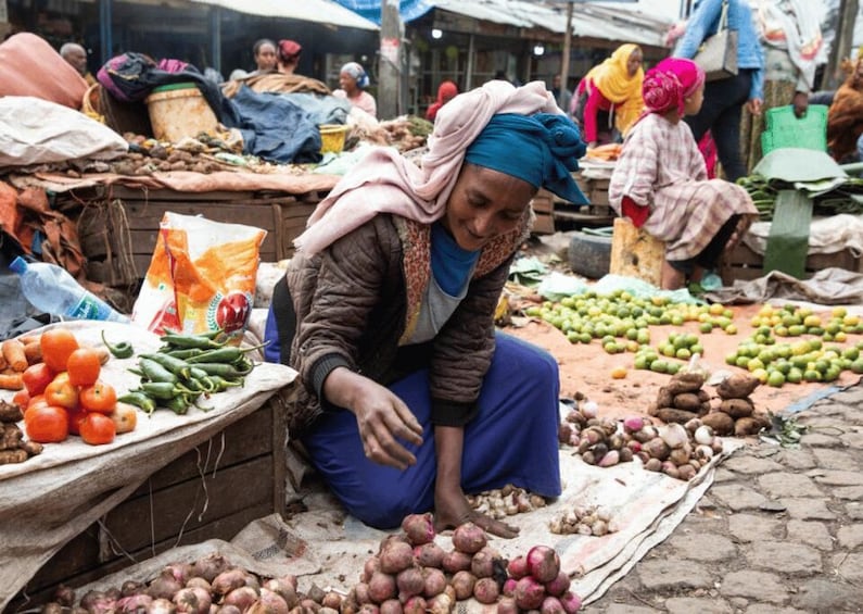 A market scene with people selling and buying vegetables. 4