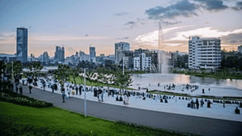 A cityscape with a river, a park with people, and modern buildings. 2