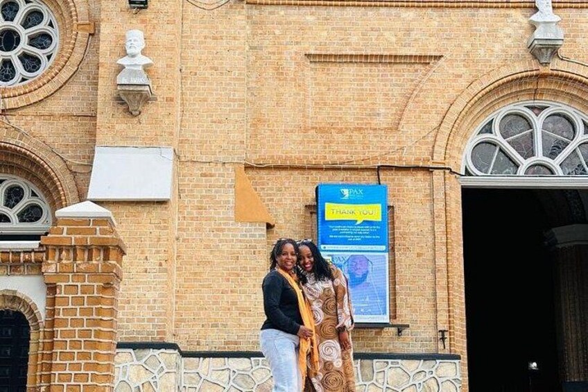 Un bâtiment en briques avec des fenêtres en arc de cercle et une enseigne bleue sur laquelle on peut lire « MERCI ». 4