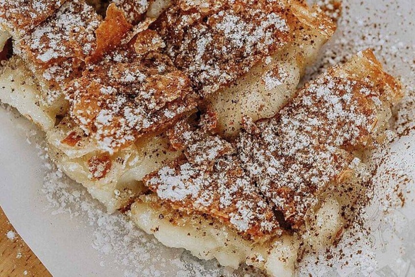 A stack of pancakes with powdered sugar on top. 3