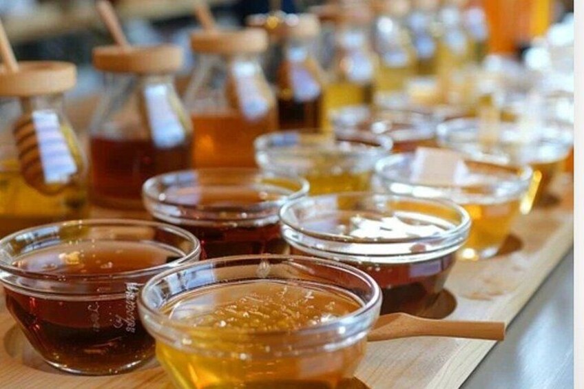Jars and bowls of honey on a wooden surface. 5