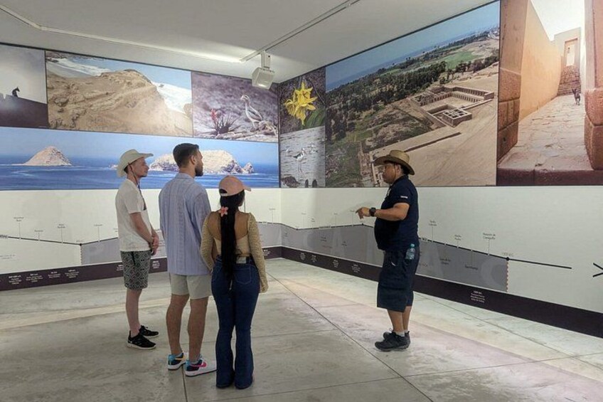 Un grupo de personas mirando fotografías grandes exhibidas en una pared de un museo. 4