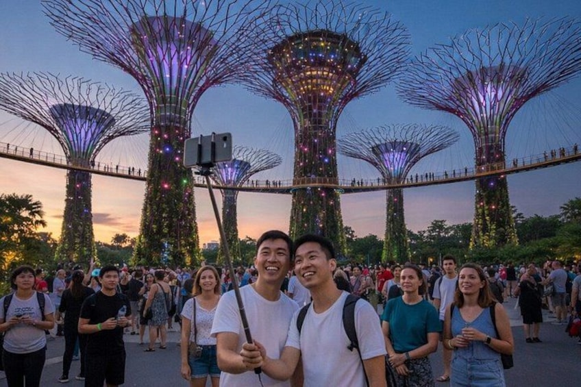 A group of people taking a selfie with the Gardens by the Bay at sunset. 1