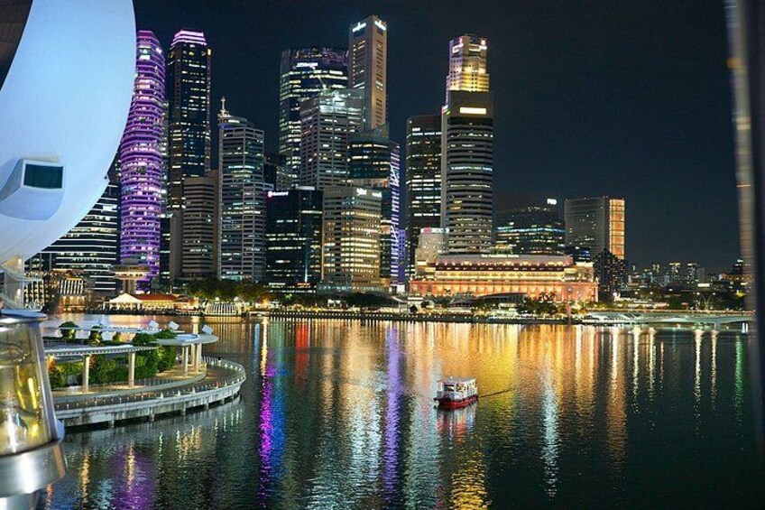 A nighttime cityscape with illuminated skyscrapers reflecting on the water. 3