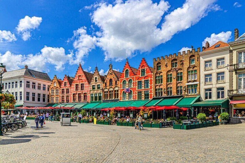 Una plaza empedrada con edificios coloridos y cafés al aire libre. 1