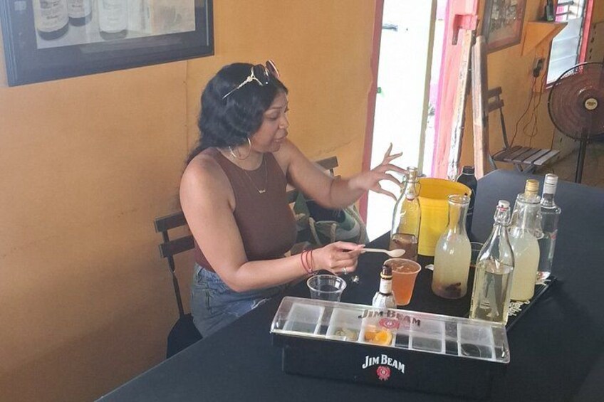 Una persona sentada a una mesa con una bebida y una botella. 5