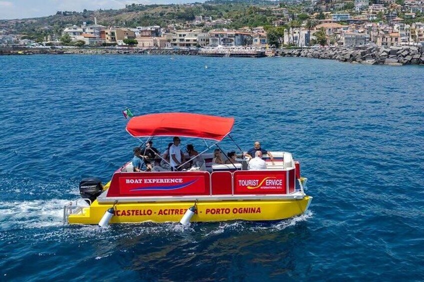 Un'imbarcazione gialla con una copertura rossa, con la scritta 'Boat Experience' e 'Servizio Turistico' sull'acqua. 4
