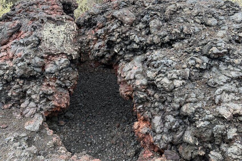 A volcanic crater with rough, dark volcanic rock and a central depression. 5