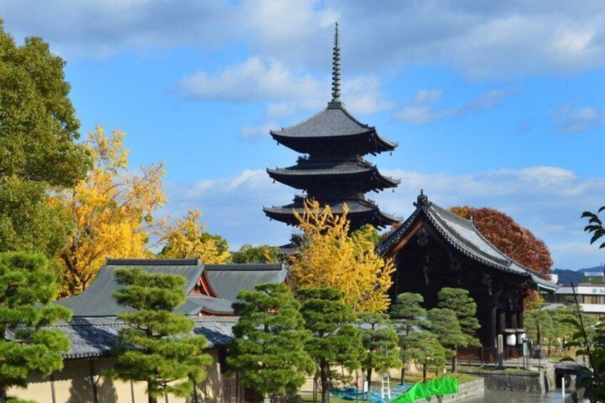 A traditional Japanese pagoda surrounded by autumn trees and a small shrine. 5