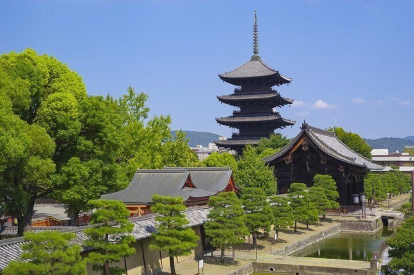 A traditional Japanese temple with a pagoda, surrounded by lush greenery and a pond. 1