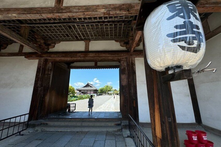 A traditional Japanese gate with wooden beams and a sign with Japanese characters. 3