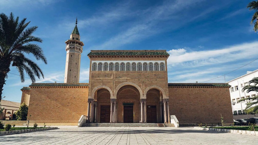 A mosque with a tall minaret and a large entrance with arches. 4
