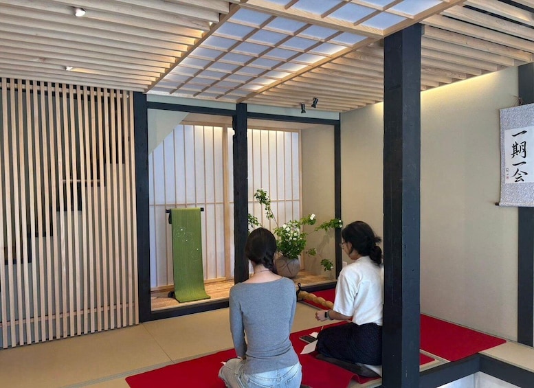 A room with a tatami mat floor, a green towel, and a plant. 2