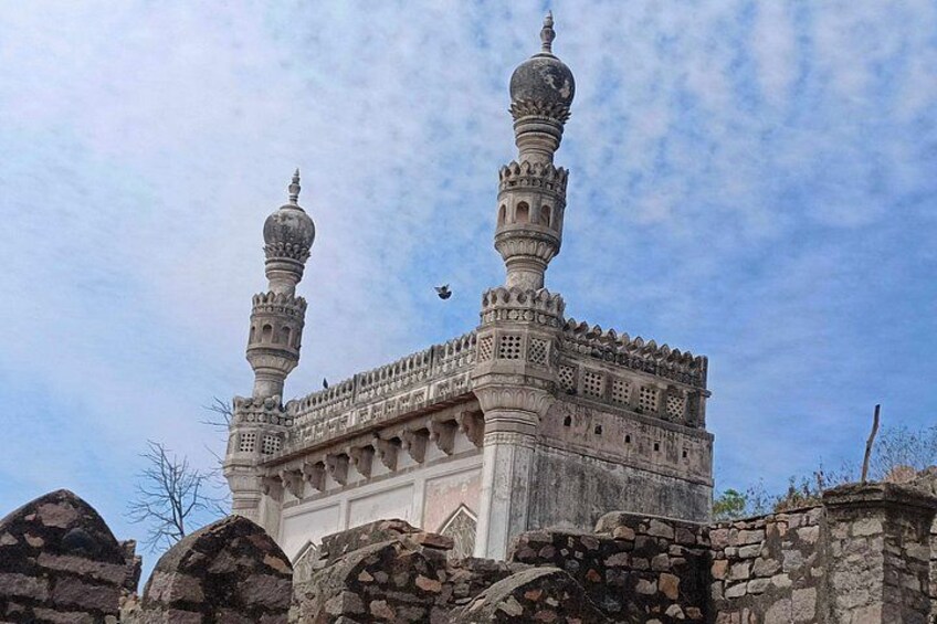 Un bâtiment historique doté de deux minarets et d’un dôme, entouré de murs de pierre. 4