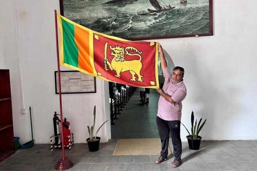 En person som håller i en flagga med ett lejon som emblem. 1