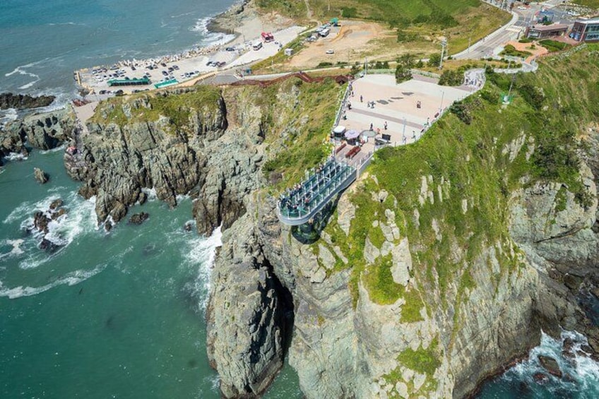 Eine Küstenklippe mit Aussichtsplattform, Strand und Parkplatz. 3