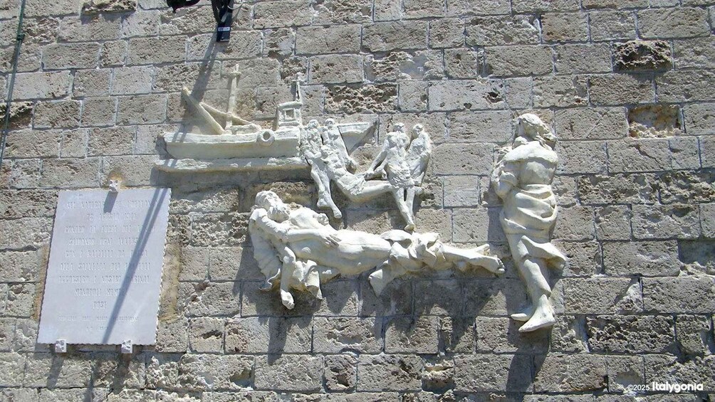 A stone relief with figures and a plaque on a wall. 3