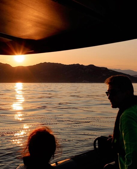 A sunset over a body of water with mountains in the background. 5